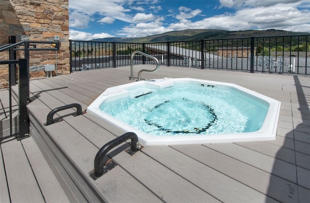 view of swimming pool featuring a mountain view and hot tub deck surround