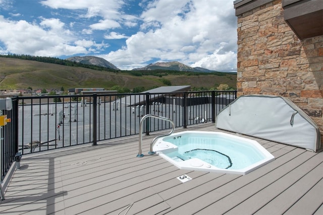 view of swimming pool with a mountain view and hot tub deck surround