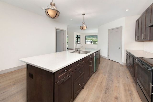 kitchen featuring black appliances, dark brown cabinetry, a sink, and light countertops