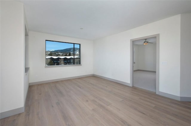 empty room with light wood finished floors and baseboards