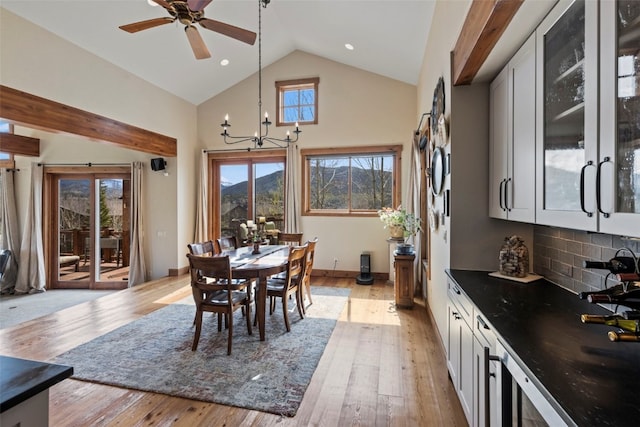 34 Snow Peak Ct, Dillon, CO 80435 - dining room with a chandelier, high vaulted ceiling, light wood-style floors, a ceiling fan, and baseboards