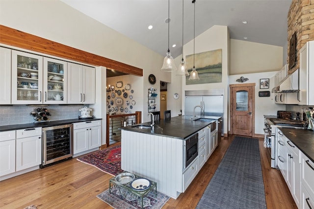 34 Snow Peak Ct, Dillon, CO 80435 - kitchen with beverage cooler, built in appliances, a sink, a center island with sink, and under cabinet range hood