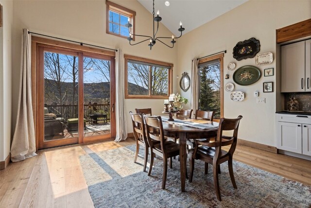34 Snow Peak Ct, Dillon, CO 80435 - dining area featuring a chandelier, light wood-type flooring, baseboards, high vaulted ceiling, and a mountain view