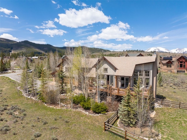 34 Snow Peak Ct, Dillon, CO 80435 - back of property with a chimney, a shingled roof, and a deck with mountain view