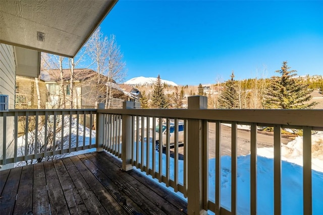 snow covered deck with a mountain view