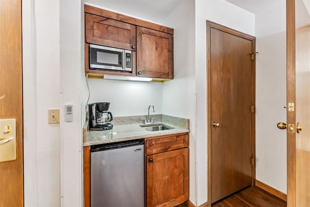 100 S Park Ave Unit E111, 112, Breckenridge, CO 80424 - kitchen featuring appliances with stainless steel finishes, a sink, light stone counters, dark wood-type flooring, and brown cabinetry