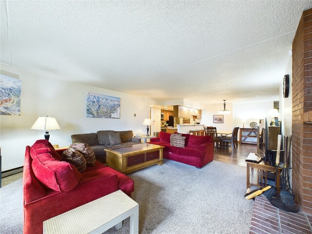 carpeted living room featuring a textured ceiling and a brick fireplace