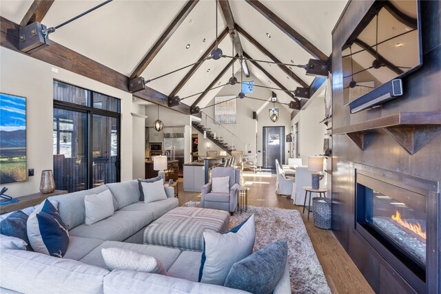 living room with beamed ceiling, hardwood / wood-style flooring, high vaulted ceiling, and ceiling fan