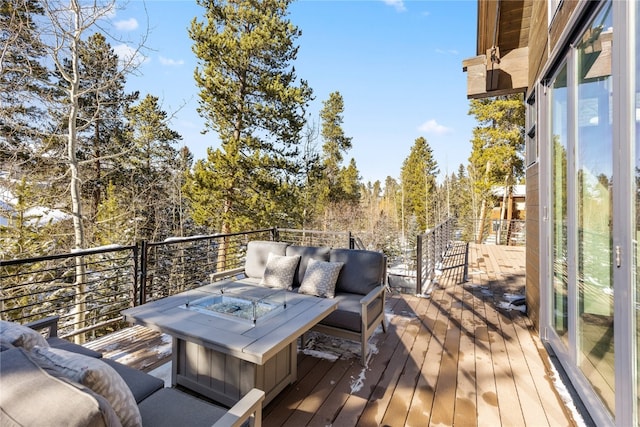 wooden deck featuring an outdoor living space with a fire pit