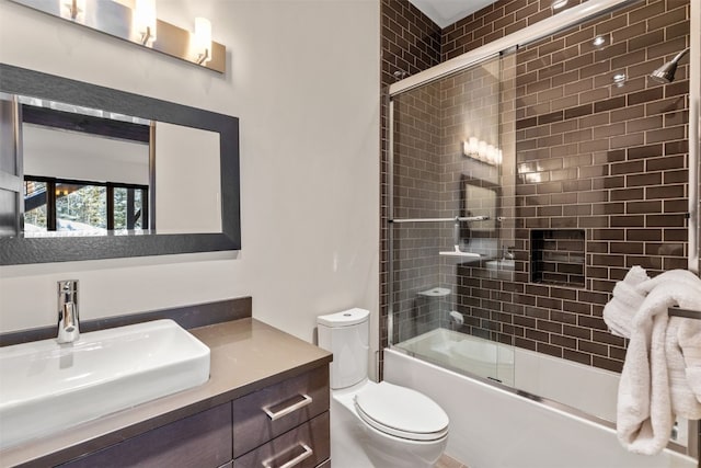 full bathroom with vanity, toilet, and bath / shower combo with glass door