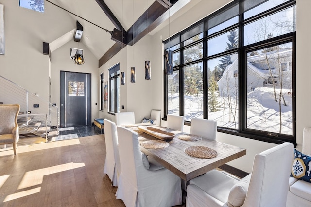 dining space featuring beamed ceiling, high vaulted ceiling, dark hardwood / wood-style floors, and a notable chandelier