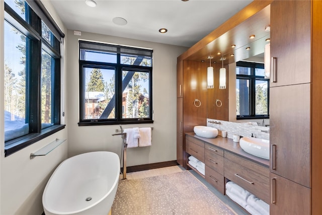 bathroom featuring decorative backsplash, vanity, and a tub