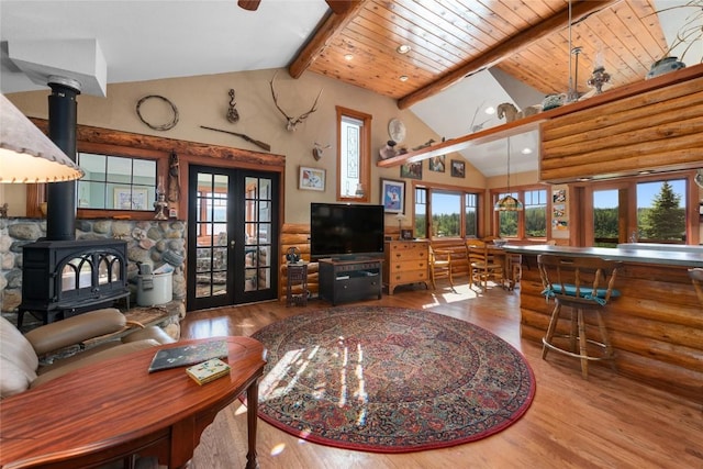 57610 Longfellow Way, Clark, CO 80428 - living room with french doors, wood finished floors, a wood stove, beamed ceiling, and log walls