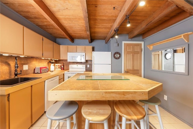 kitchen featuring a sink, light tile patterned flooring, white appliances, wood ceiling, and beamed ceiling