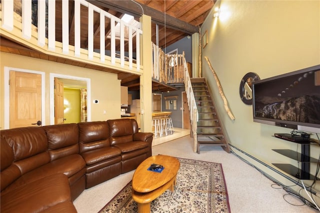 living room featuring a towering ceiling, carpet, and stairs
