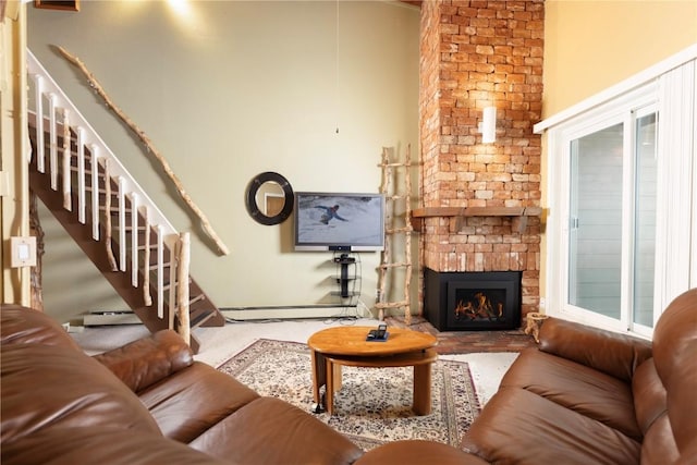 carpeted living room with a towering ceiling, a fireplace, baseboards, a baseboard radiator, and stairs