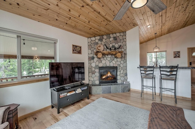 living room with light wood finished floors, baseboards, lofted ceiling, wooden ceiling, and a fireplace