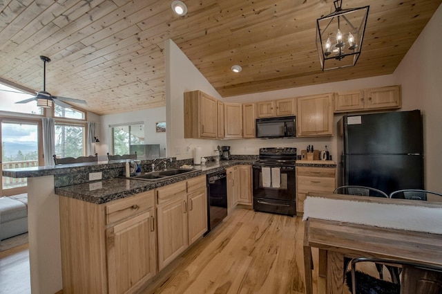 kitchen featuring lofted ceiling, light brown cabinetry, a sink, and black appliances