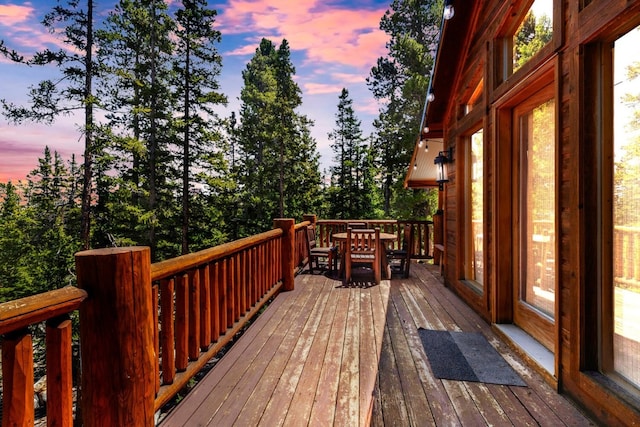 deck at dusk featuring outdoor dining area