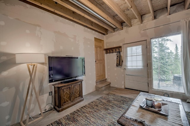 living room featuring concrete flooring and stairs