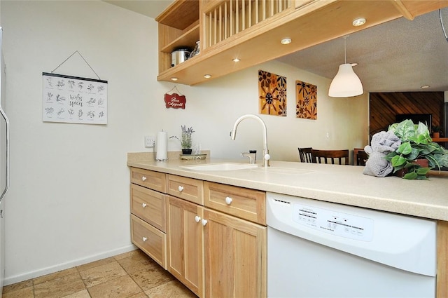 kitchen with baseboards, light brown cabinetry, white dishwasher, and light countertops