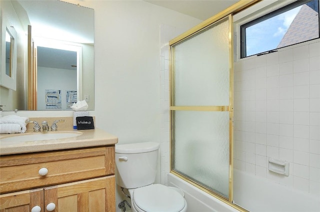 bathroom featuring enclosed tub / shower combo, toilet, and vanity