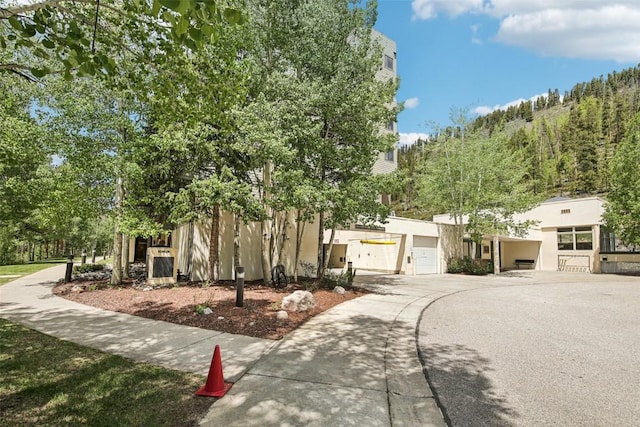 22097 Saints John Rd Unit 2537, Keystone, CO 80435 - view of front of property featuring a garage, concrete driveway, and stucco siding