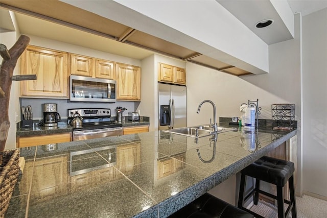 22097 Saints John Rd Unit 2537, Keystone, CO 80435 - kitchen featuring stainless steel appliances, tile countertops, light brown cabinetry, a kitchen bar, and a peninsula
