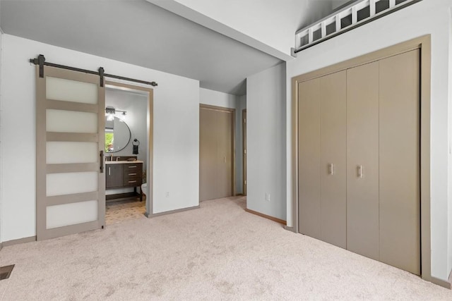 818 Broad St, Steamboat Springs, CO 80487 - unfurnished bedroom with carpet, a barn door, a closet, ensuite bathroom, and baseboards