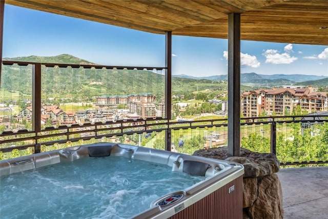 view of patio / terrace with a mountain view and a hot tub