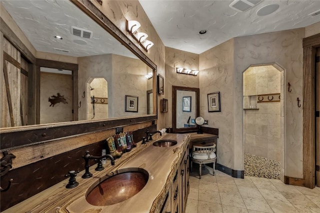 full bathroom with visible vents, a sink, and double vanity