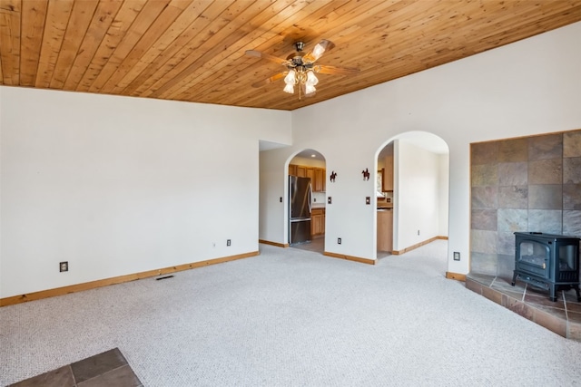 316 3rd St, Fairplay, CO 80440 - unfurnished living room featuring carpet floors, wooden ceiling, a wood stove, ceiling fan, and baseboards