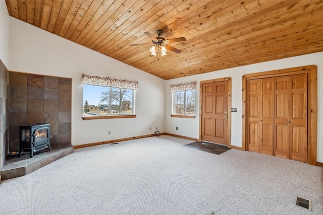 316 3rd St, Fairplay, CO 80440 - unfurnished living room with carpet flooring, vaulted ceiling, a wood stove, ceiling fan, and baseboards