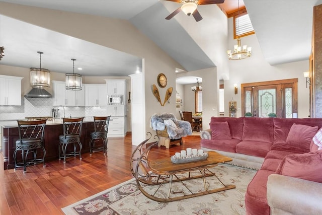 22755 Snowbird Trl, Oak Creek, CO 80467 - living room featuring a chandelier, ceiling fan, arched walkways, wood finished floors, and lofted ceiling