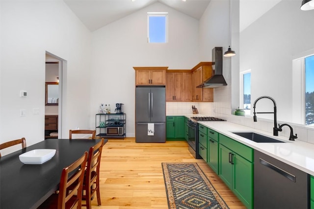21185 County Road 16, Oak Creek, CO 80467 - kitchen with high vaulted ceiling, wall chimney exhaust hood, a sink, green cabinets, and stainless steel appliances