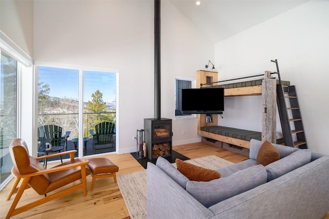 21185 County Road 16, Oak Creek, CO 80467 - living area with high vaulted ceiling, baseboards, a wood stove, and light wood-style floors