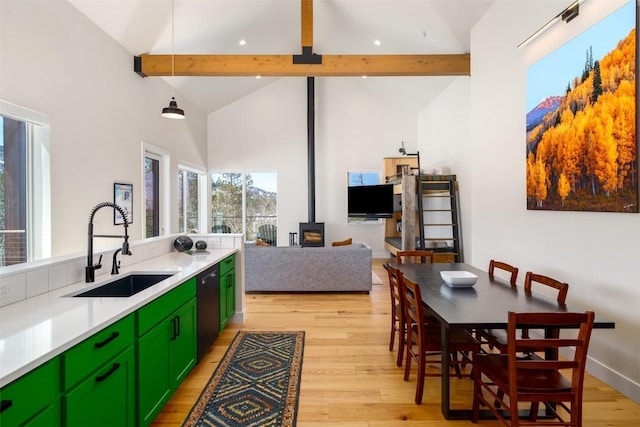 21185 County Road 16, Oak Creek, CO 80467 - kitchen featuring a wood stove, beamed ceiling, a sink, dishwasher, and green cabinets