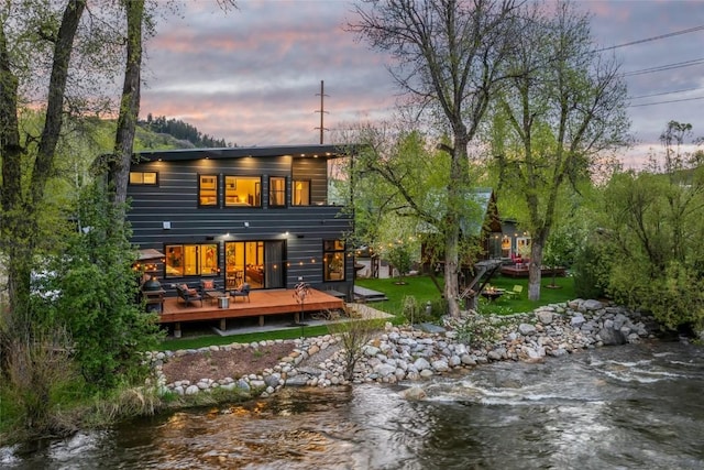 410 River Rd, Steamboat Springs, CO 80487 - back of house at dusk with a deck with water view