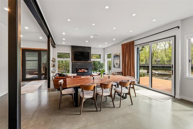 410 River Rd, Steamboat Springs, CO 80487 - dining room with a fireplace, concrete flooring, recessed lighting, and baseboards