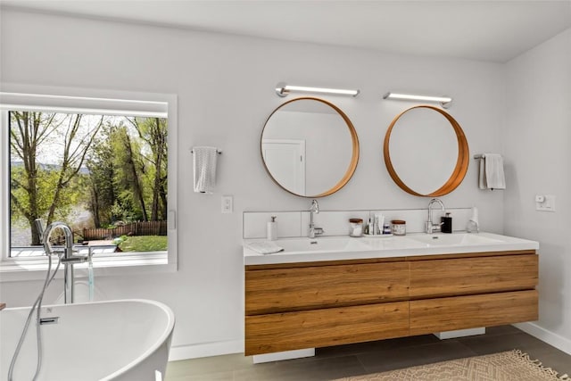 410 River Rd, Steamboat Springs, CO 80487 - full bath featuring double vanity, a freestanding tub, tile patterned flooring, and baseboards