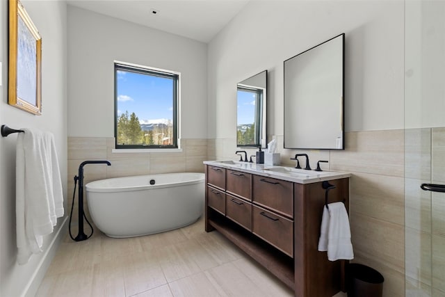 403 Revett Dr, Breckenridge, CO 80424 - full bathroom featuring tile walls, a freestanding tub, double vanity, and wainscoting
