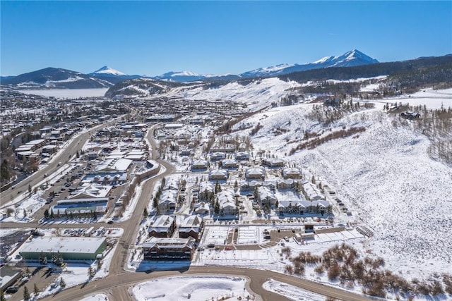 snowy aerial view with a mountain view and a residential view