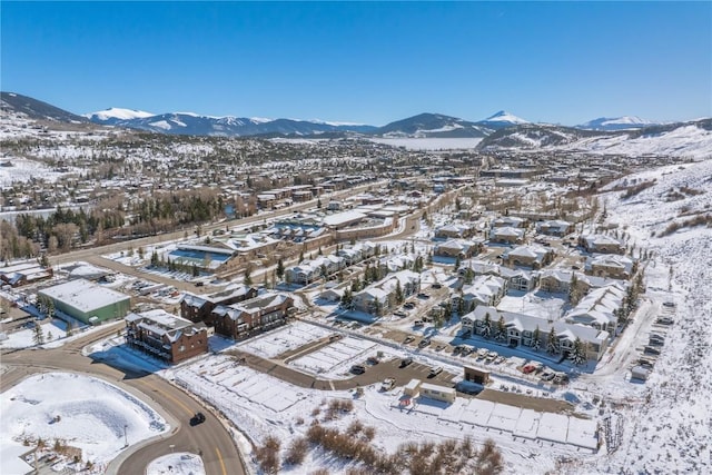 snowy aerial view with a mountain view and a residential view