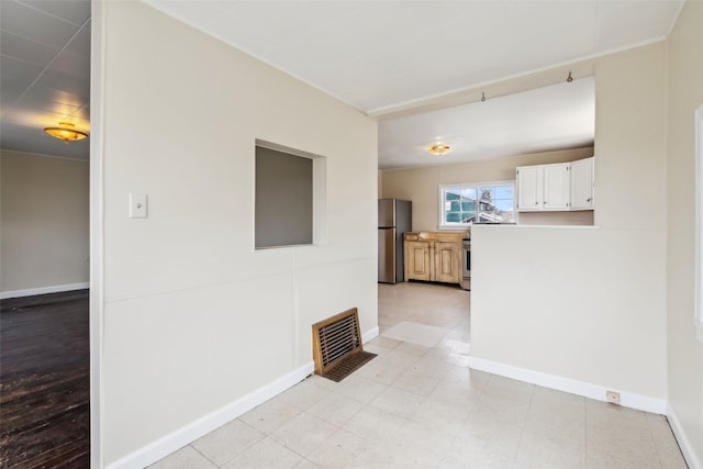 spare room featuring baseboards and visible vents