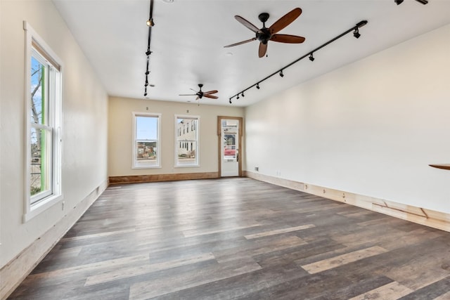 unfurnished room with a healthy amount of sunlight, wood finished floors, ceiling fan, and track lighting