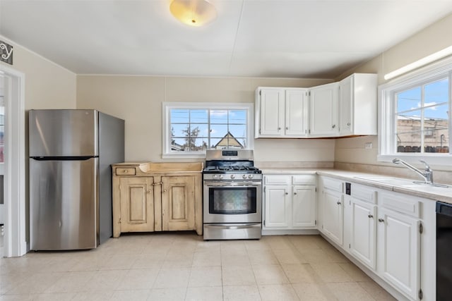 kitchen featuring light countertops, white cabinets, appliances with stainless steel finishes, and a sink