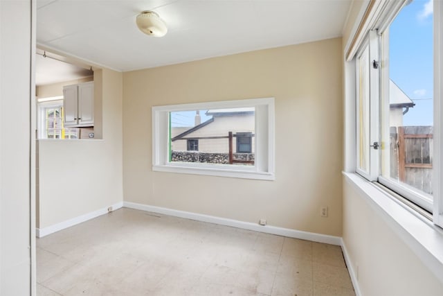unfurnished room with light floors and baseboards