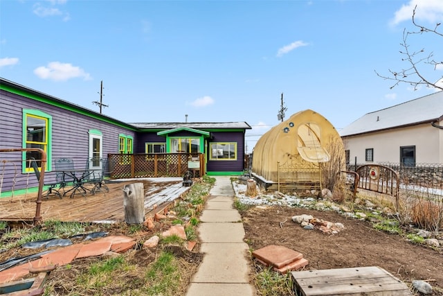 back of property with a wooden deck and fence