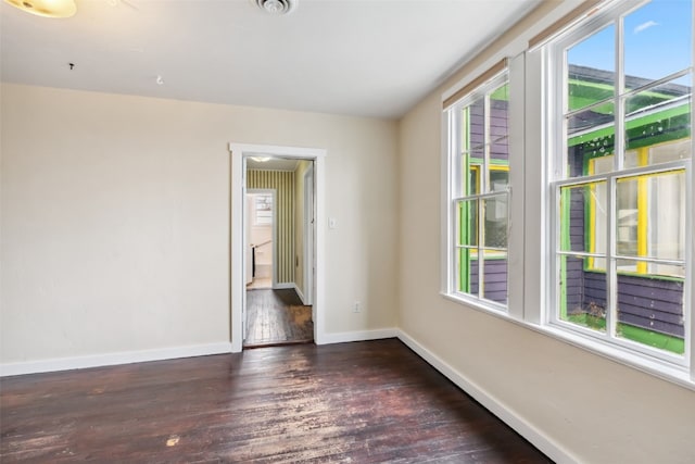 empty room featuring baseboards and hardwood / wood-style floors