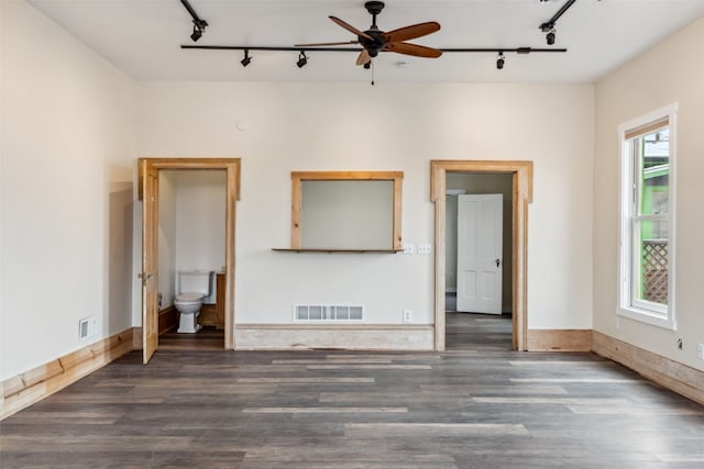 unfurnished room with track lighting, visible vents, and wood finished floors